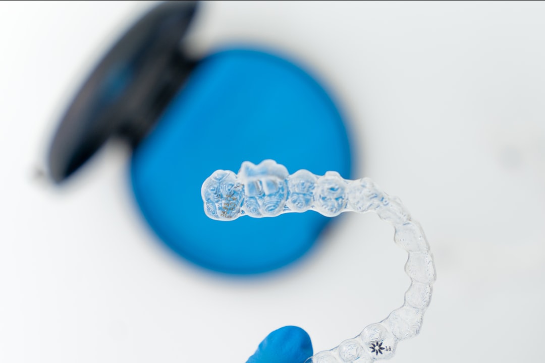 A clear dental retainer being lifted from its case
